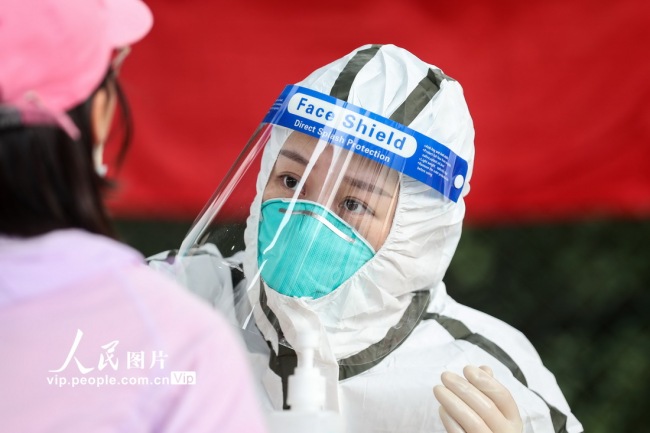 8月9日拍摄于扬州邗江区邗江中学检测点,医护人员正在为居民进行核酸