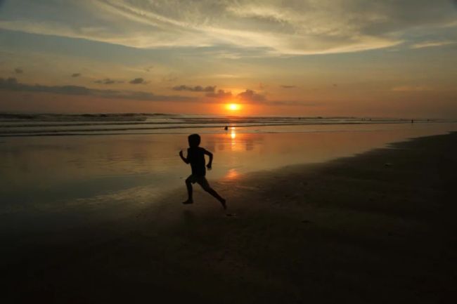 2015年9月28日，一个孩子日落时分在尼加拉瓜南圣拉斐尔市波乔米尔沙滩上奔跑。（新华社发，约翰·布斯托斯摄）