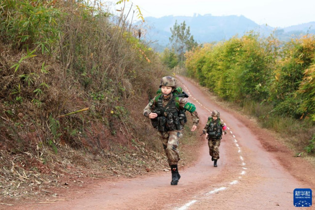 在“精武联勤-2021”战斗体能比武中，参赛队员携装冲刺陡坡（12月13日摄）。