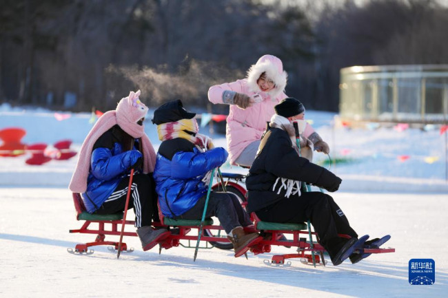 12月24日，在太阳岛雪博会园区，游客在娱乐区体验冰上项目。