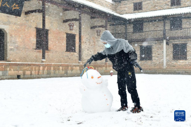 12月26日，在湖南省娄底市双峰县荷叶镇，小朋友在堆雪人。