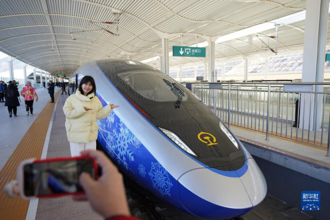 1月6日，在京张高铁太子城站，一位记者在G9981次北京冬奥列车车厢前合影。