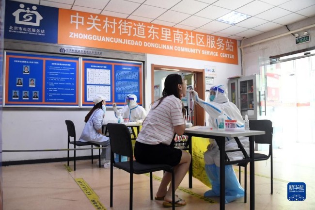 　5月5日，在北京市海淀区中关村街道东里南社区临时核酸检测采样点，医务人员进行核酸采样。