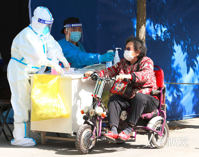 2022年5月15日，一位坐輪椅的老年人在北京市朝陽區的一處核酸檢測采樣工作站進行咽拭子采樣。