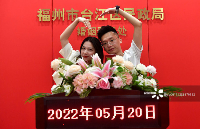 2022年5月20日，一对新人在福州市台江区民政局婚姻登记处拍照留念。