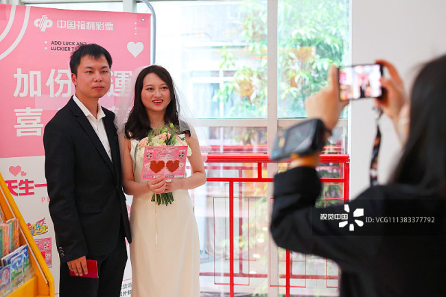 2022年5月20日，重庆市沙坪坝区民政局婚姻登记处，新人拿着福彩“天生一对”彩票合影留念。