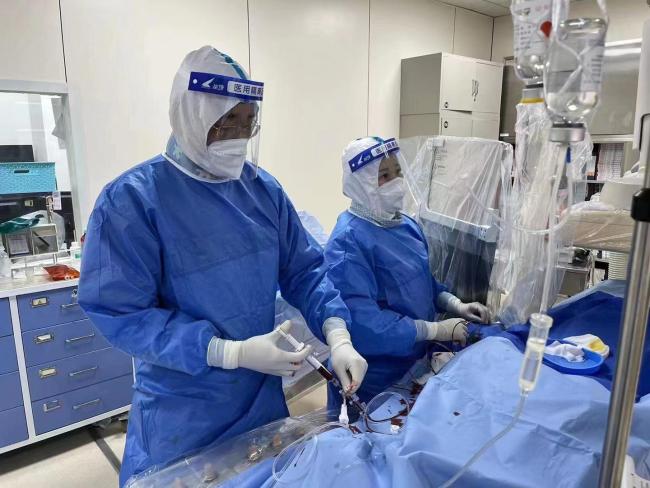 心内科医生包恩泽（左）和徐世莹（右）在导管室为病人做介入手术。受访者供图 