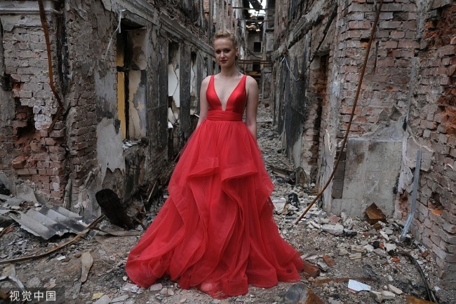 乌克兰女生穿红色礼服参加废墟里的毕业舞会