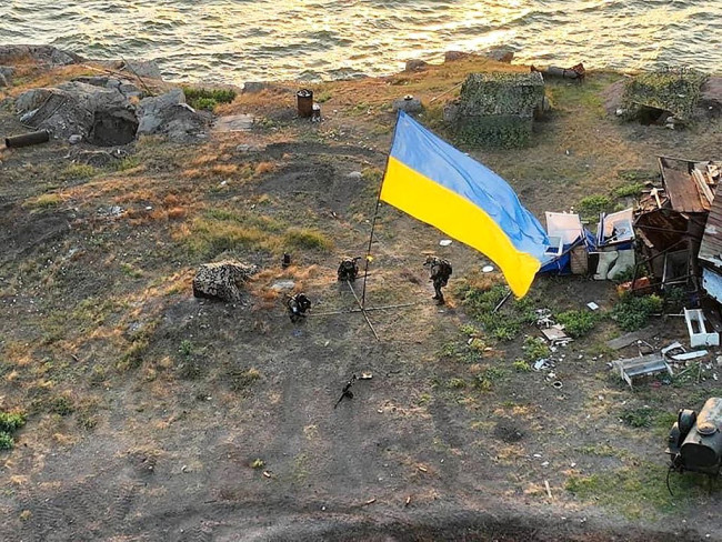 当地时间2022年7月7日，蛇岛，一名乌克兰士兵在Bile村悬挂乌克兰国旗。2022年7月4日，乌克兰军方发言人表示，乌克兰已经重新在蛇岛安装了国旗。