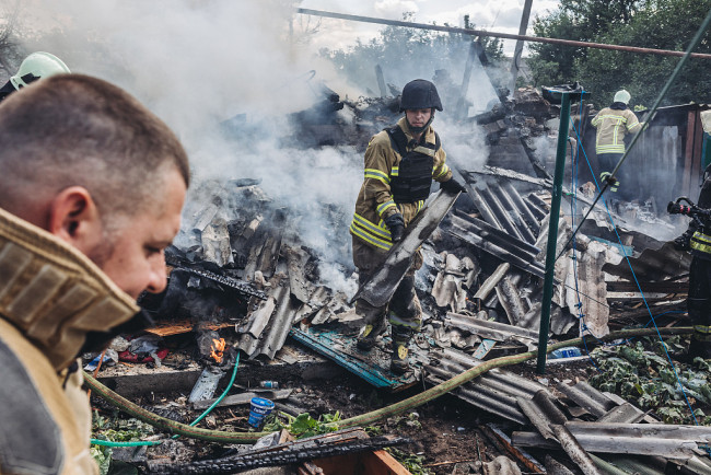 当地时间2022年7月19日，顿涅茨克地区巴赫穆特市，当地遭受炮击后建筑受损严重，居民和消防员在进行灭火。