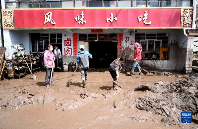 8月18日，受災群眾在青海省西寧市大通回族土族自治縣青山鄉清理淤泥開展自救。