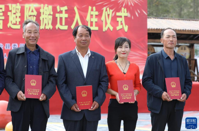 9月15日，甘肃省武威市祁连镇搬迁群众代表拿到不动产权证书。张智敏 摄