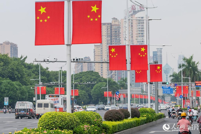 9月28日，广西南宁民族大道两旁的路灯杆上，挂上了鲜艳的五星红旗。人民网记者 严立政摄