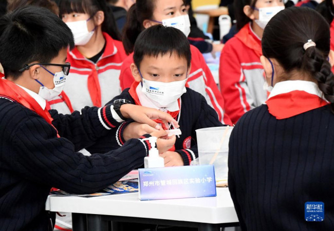 10月12日，学生在河南省科技馆收看“天宫课堂”第三课时做实验。 新华社记者 李安 摄