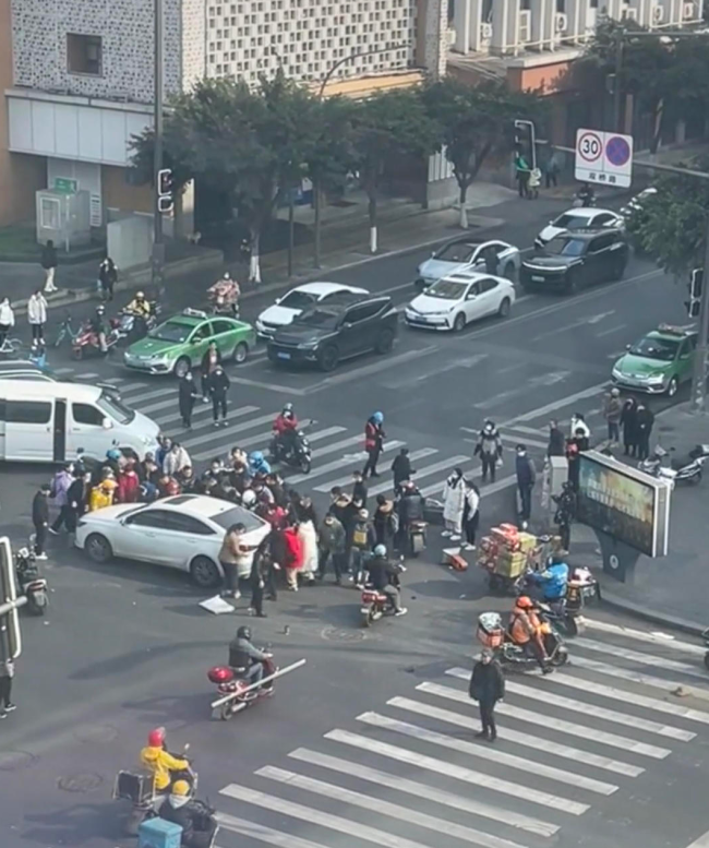 轿车与两辆电瓶车碰撞 大叔被卷入车底20人抬车救援 