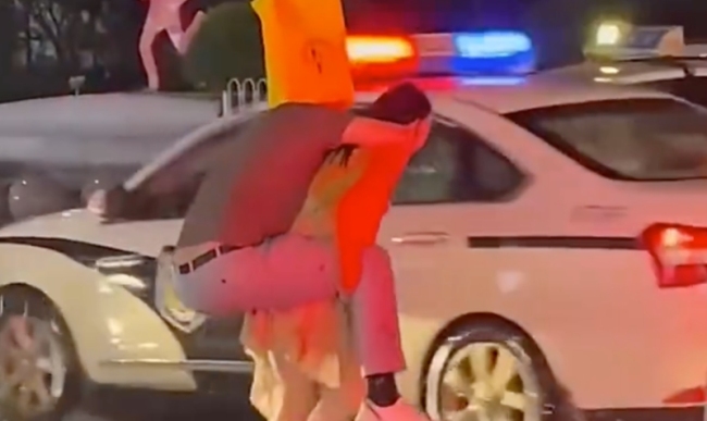 女子暴雨天背男友过马路：还穿着高跟鞋！