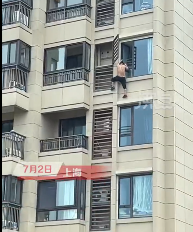 吓人！男子赤身爬高楼外装空调 拍摄者：至少10楼以上