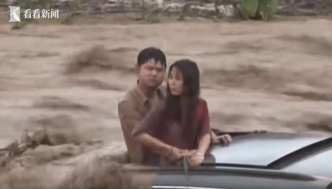 路遇洪水男子让女友先走 经过三个多小时的紧张救援，两人平安获救