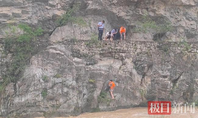 河水猛涨女子被困山崖边：仅有不足20厘米落脚点