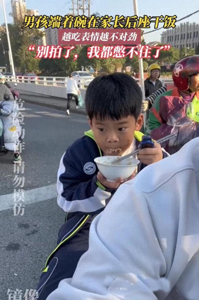 小男孩在電動車後座乾飯發現被偷拍後害羞的樣子太可愛了