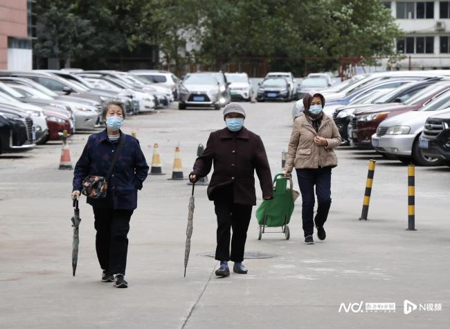 寒潮袭来气温骤降 广州街头小姐姐冻得裹被子