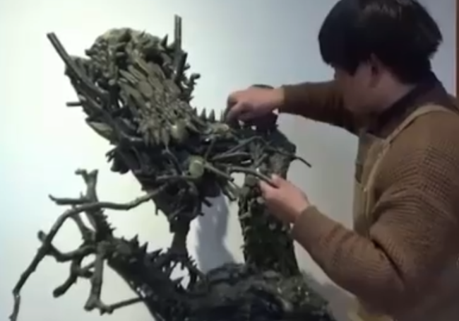 男子耗时1个月用2000多根树枝，做出了1米高的青龙雕塑