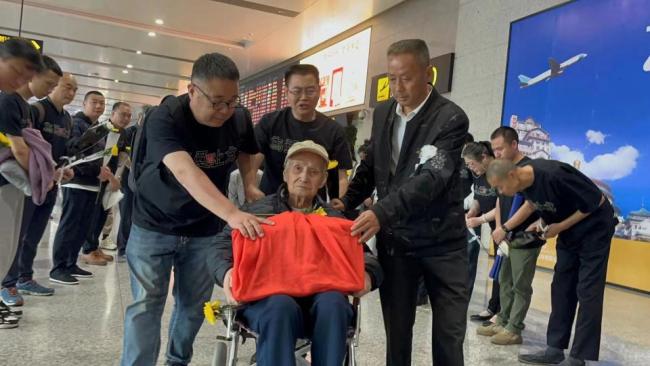 志愿者护送"抗日连长"遗骸回四川 94岁儿子机场深情迎接
