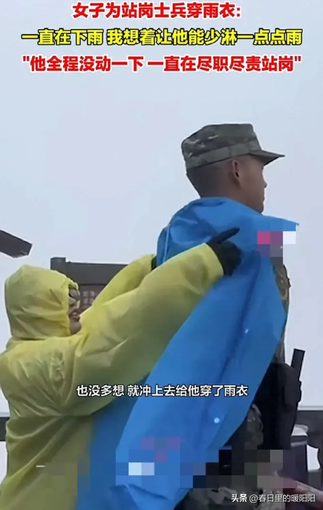 游客给雨中站岗武警战士穿雨衣
