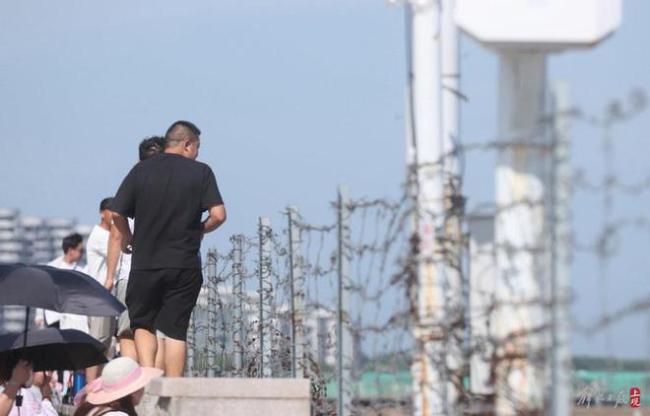 上海奉贤海湾游客翻越铁丝网下海 无视安全警示翻墙游玩