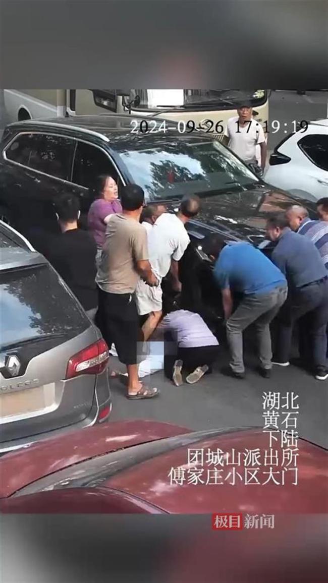 惊险！女童过马路被压车底 路人合力救援