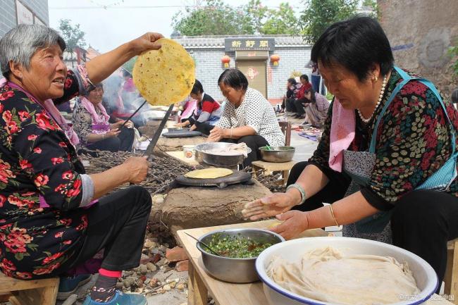 大媽村口擺桌百十號人烙饃 鄉(xiāng)情滿滿共度時光