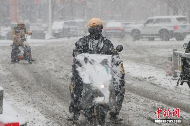 交警暴雪疏导车辆一夜冻成“雪人” 寒潮下的坚守