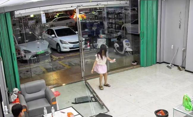 女孩推倒商家玻璃门淡定捋头发进店 大力出奇迹