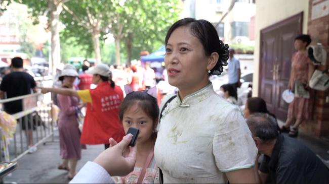 家长身旗袍拿向日葵等候考生 期盼一举夺“葵”