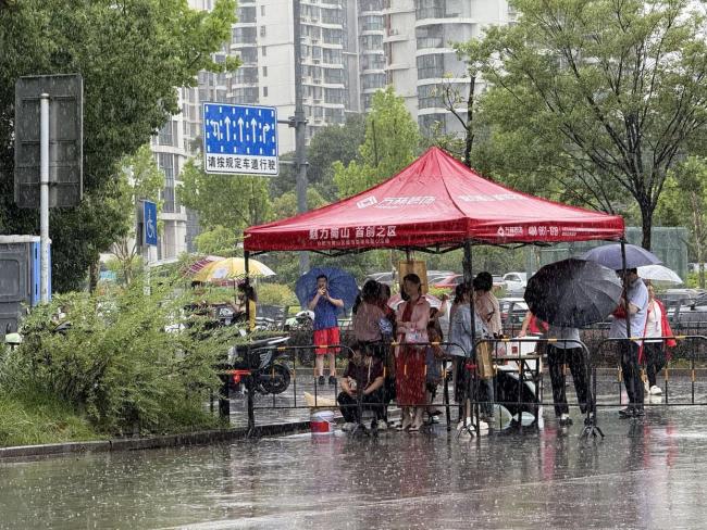 高考首日降雨 有人追梦也有人守护 雨中温情护考路