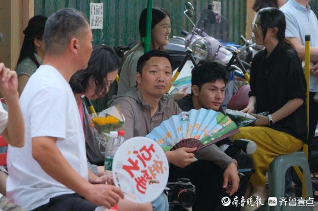 家长在高考考场外默默陪伴 暖心“陪烤”
