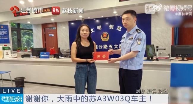 车主雨中拖走80斤雨布获奖励 见义勇为受表彰