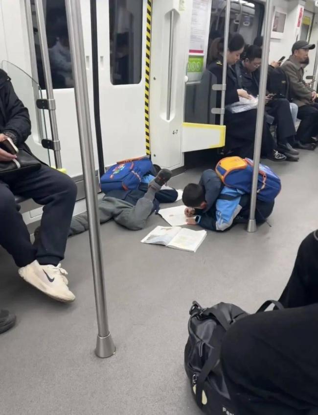 小孩哥滑铲进地铁 趴地上写作业 童年松弛感引共鸣