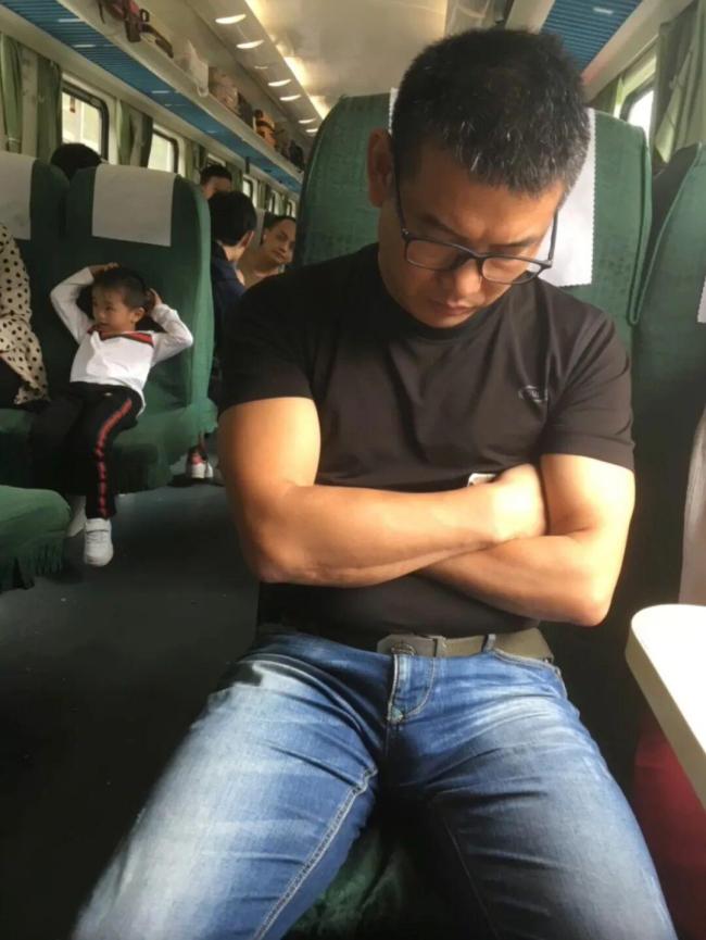 男子无座绿皮火车上站着睡着