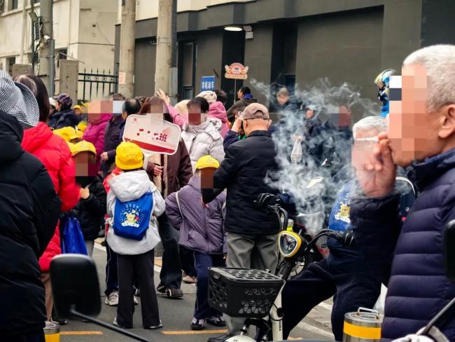 家长等孩子放学校门口抽烟引争议