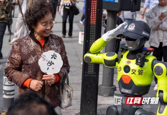 湖南长沙街头“机器人交警”上岗 新同事引市民围观