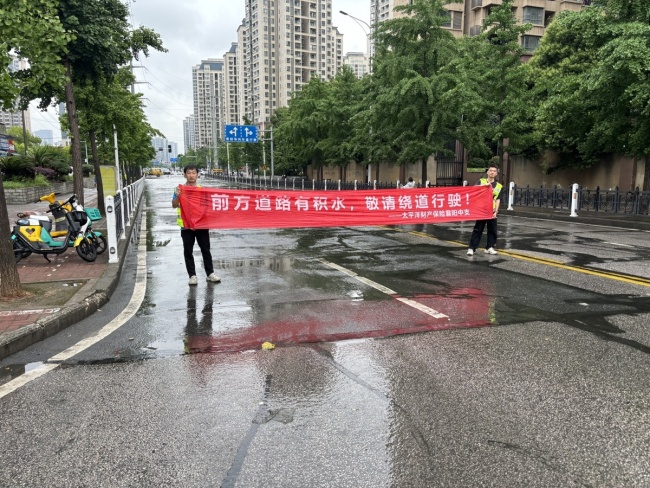 保险理赔人员蹚水救助被困车主 风雨中的“太保蓝”