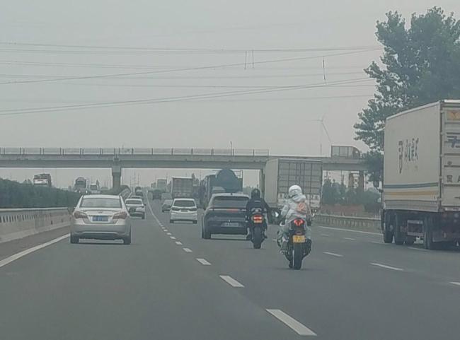 河南高速上2人骑摩托边打手势边狂奔 目击者称其时速超过120