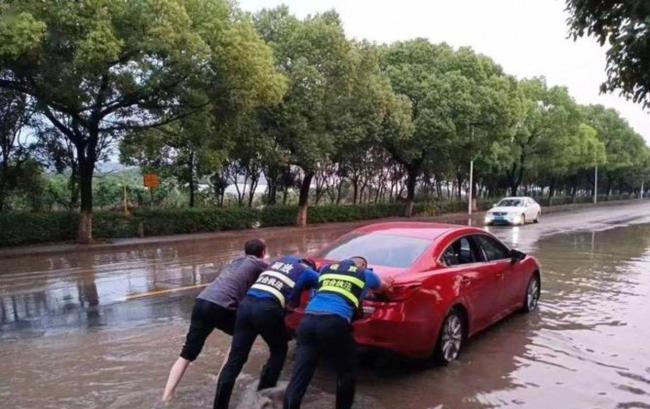 暴雨天女子执意骑车被水冲倒 众人紧急救援