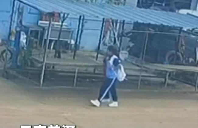 小学生捡起被风吹落的国旗
