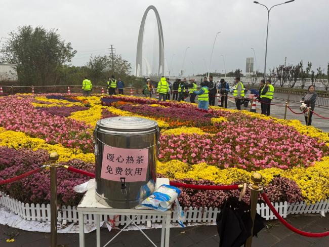 北京上百位市民雨中排队 接国庆鲜 花香传递节日温情