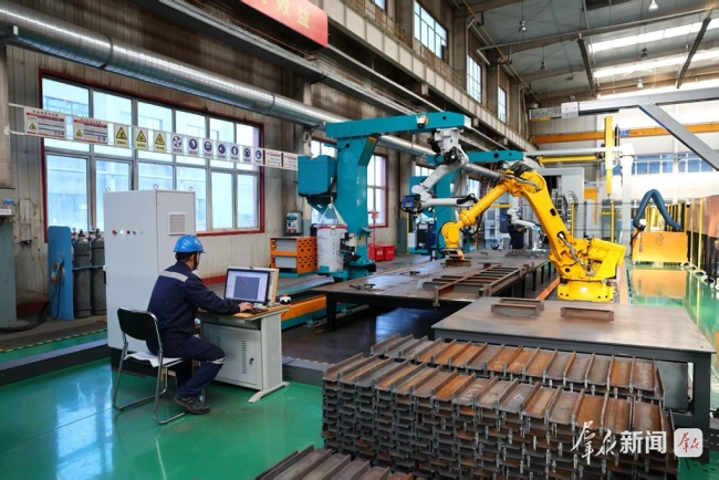 工作人员操作焊接机器人作业。