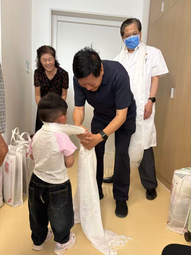 北京建藏援藏工作者协会会长金书波为小卓玛戴哈达