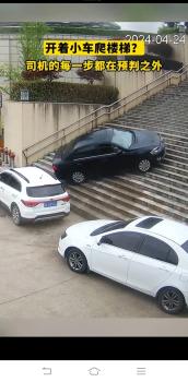 司机操作失误开着小车爬楼梯撞上路边停的白色轿车，居然还是个男司机