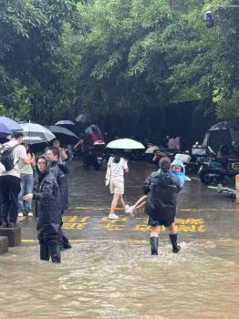 成都地鐵口工作人員為乘客發(fā)雨衣 暴雨中搭“便橋”護(hù)送安全出行
